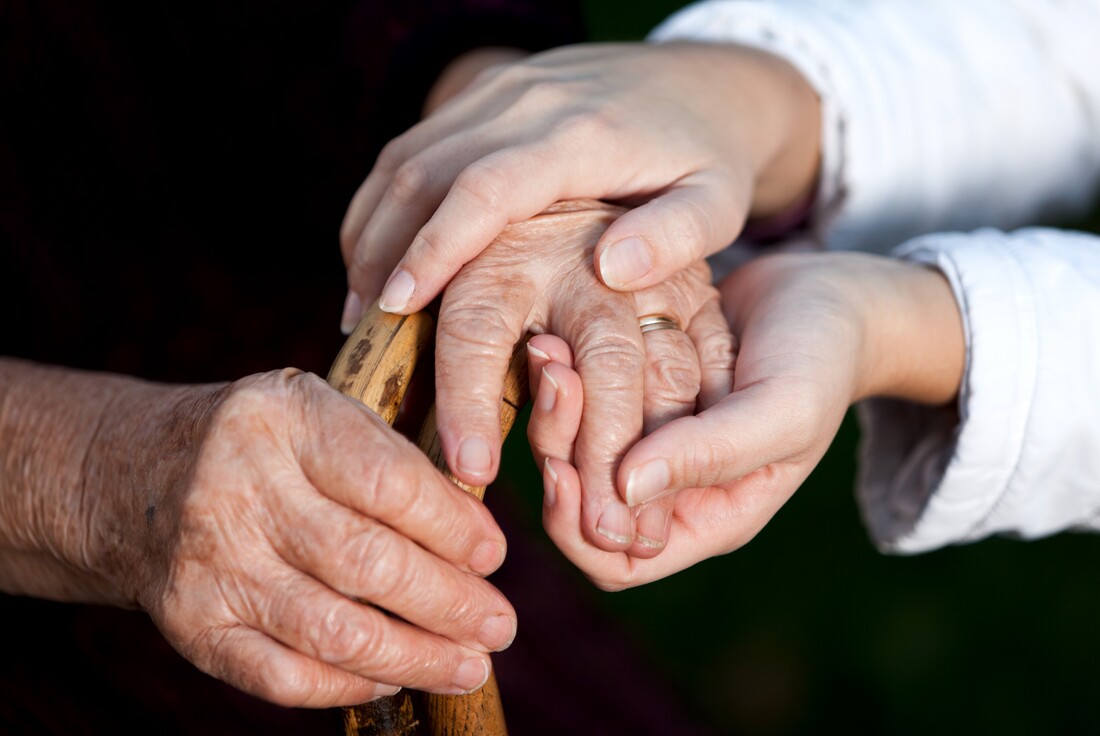 Hands holding older person's hands